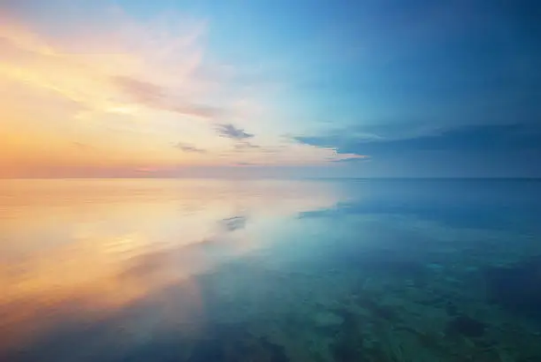 Golden sunrise reflecting on still water
